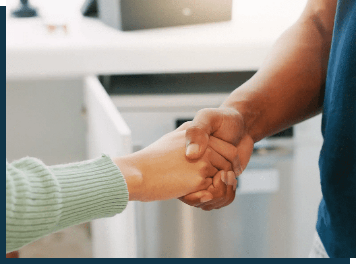 Two people shaking hands in a professional setting.